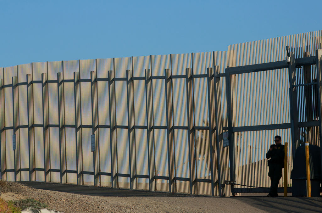 SAN YSIDRO, CA-FEB 7: A border patrol officer stands guard along the U.S.-Mexico border on Wednesday, February 7, 2018 in San Ysidro, California. The rally coincides on the eve of Congress's spending bill deadline and is urging lawmakers to pass a clean Dream Act without provisions for a border wall.(Photo by Sandy Huffaker/Getty Images)